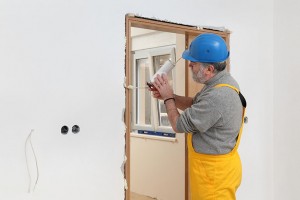 Trabajador instalando una puerta con espuma de poliuretano